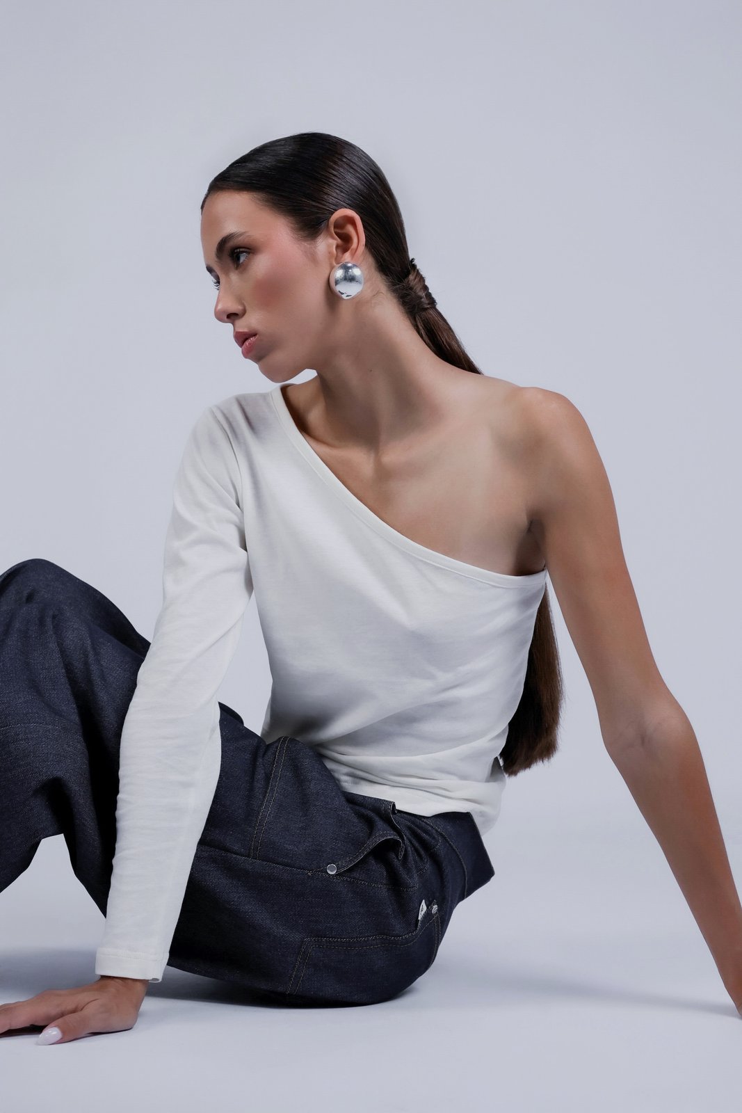 Duo de tops asymétriques Louise Blanc, porté, vue de profil, deux pièces complémentaires qui multiplient les possibilités de style et de superposition