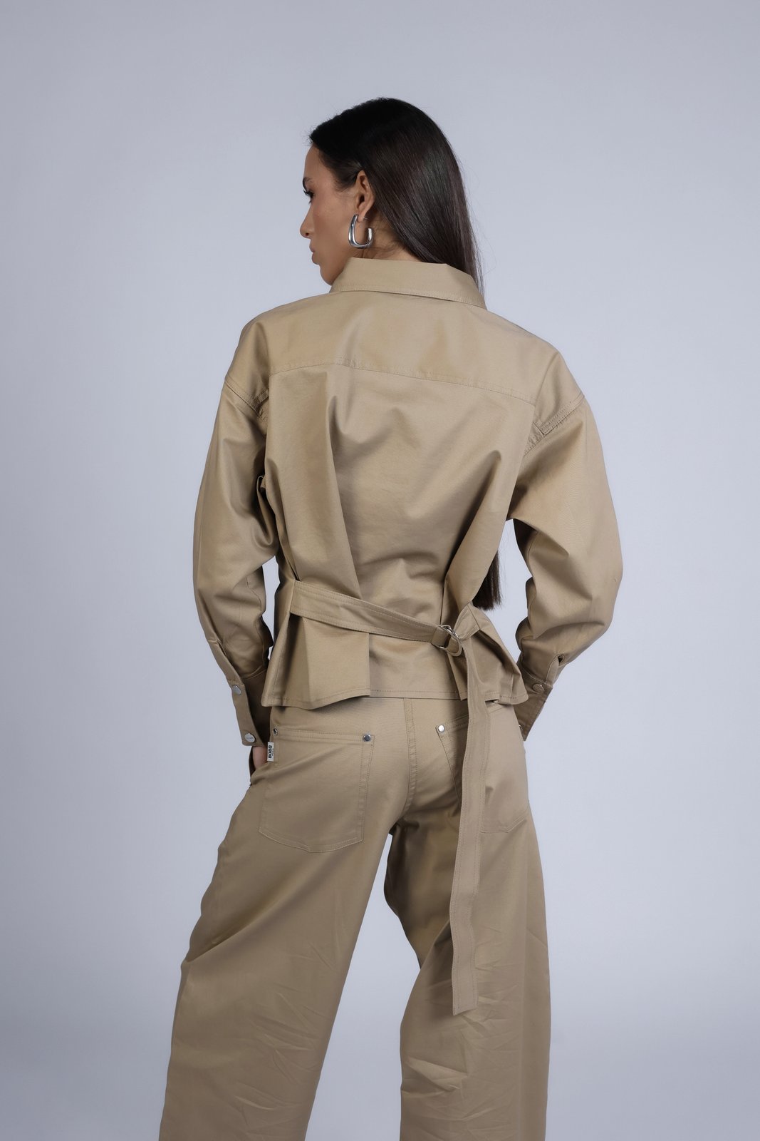Pantalon en jean ballon Léon Beige, porté en mouvement, le pantalon revisite les codes du workwear avec une coupe ballon au volume affirmé