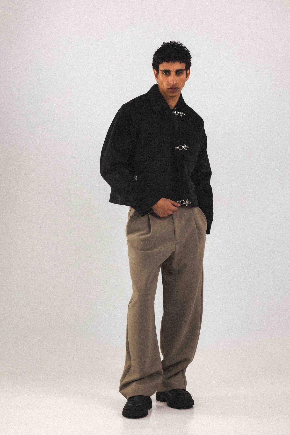 Blouson court Adam Noir, porté en mouvement, ses poignets et son col sont en velours côtelé, coupe unisexe pensée pour toutes les silhouettes