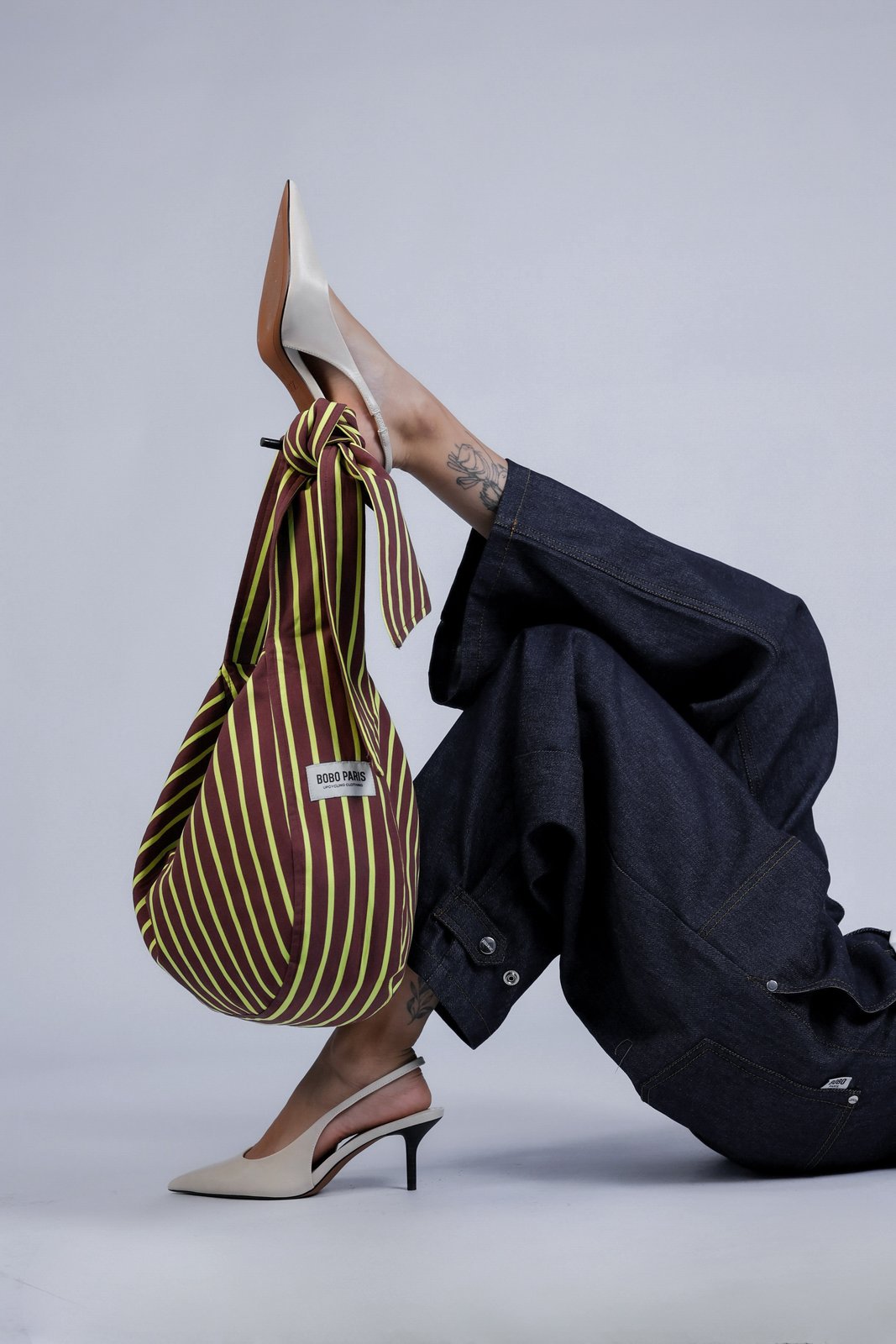 Sac à nouer à rayures jaune/marron Sasha, porté, vue de dos, offre plusieurs façons de le porter : en bandoulière classique ou à l'épaule