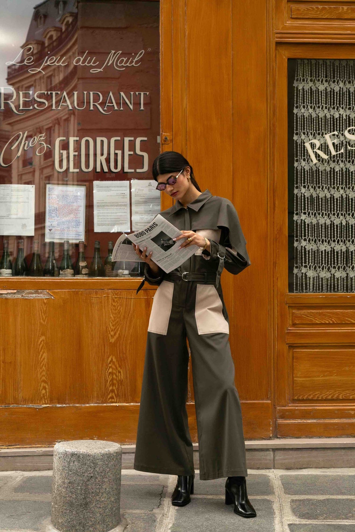 Combinaison cape Jacqueline Vert, porté de face dans la rue, la combinaison Jacqueline est une pièce forte, silhouette ample façon workwear
