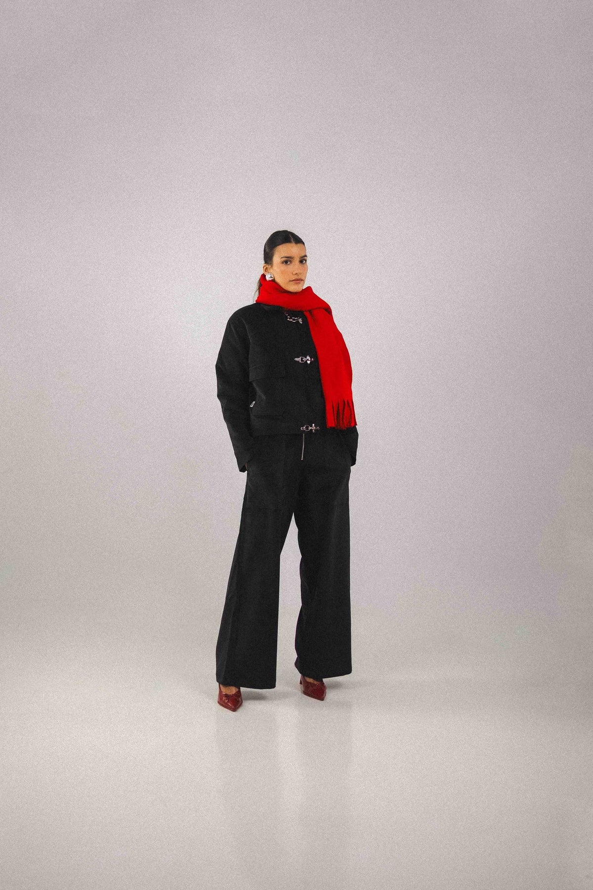 Blouson court Adam Noir, gros plan sur le tissu, avec ses trois boucles pompiers qui se ferment au-dessus du zip