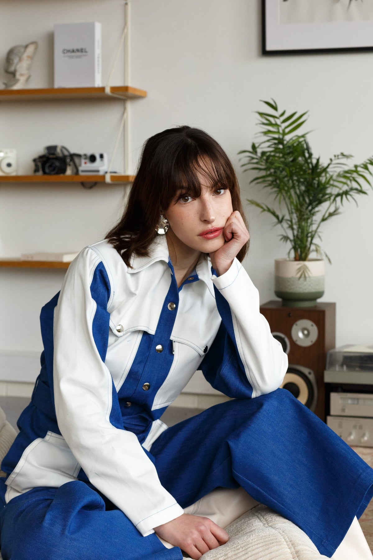 Combinaison en jean Suzie, porté, vue de profil, elle est réalisée dans un denim 100% coton et est dotée de finitions inspiration trench (bavolets, coupe oversize)