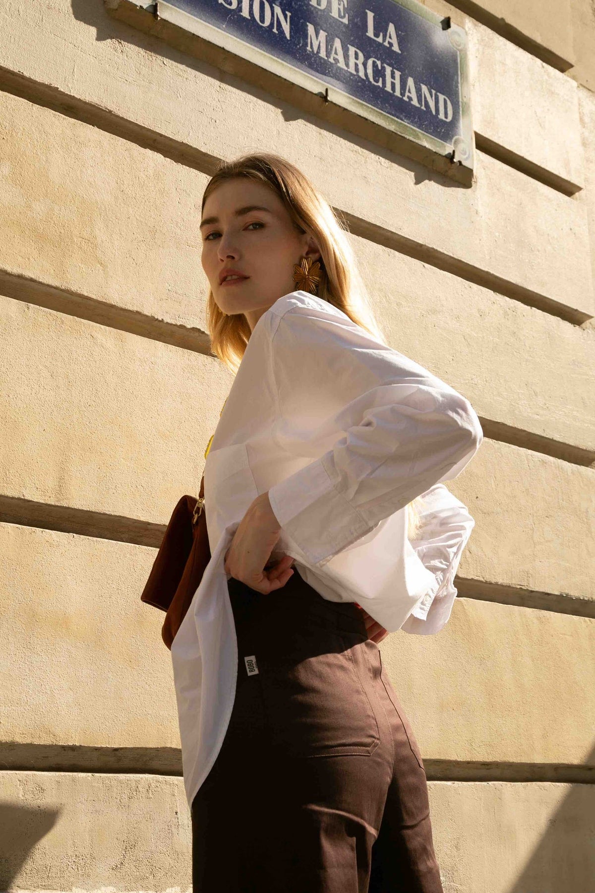Pantalon taille haute Ivy Marron, porté, vue rapprochée, sa fermeture à zip argenté apporte une touche moderne, coupe sobre et confortable