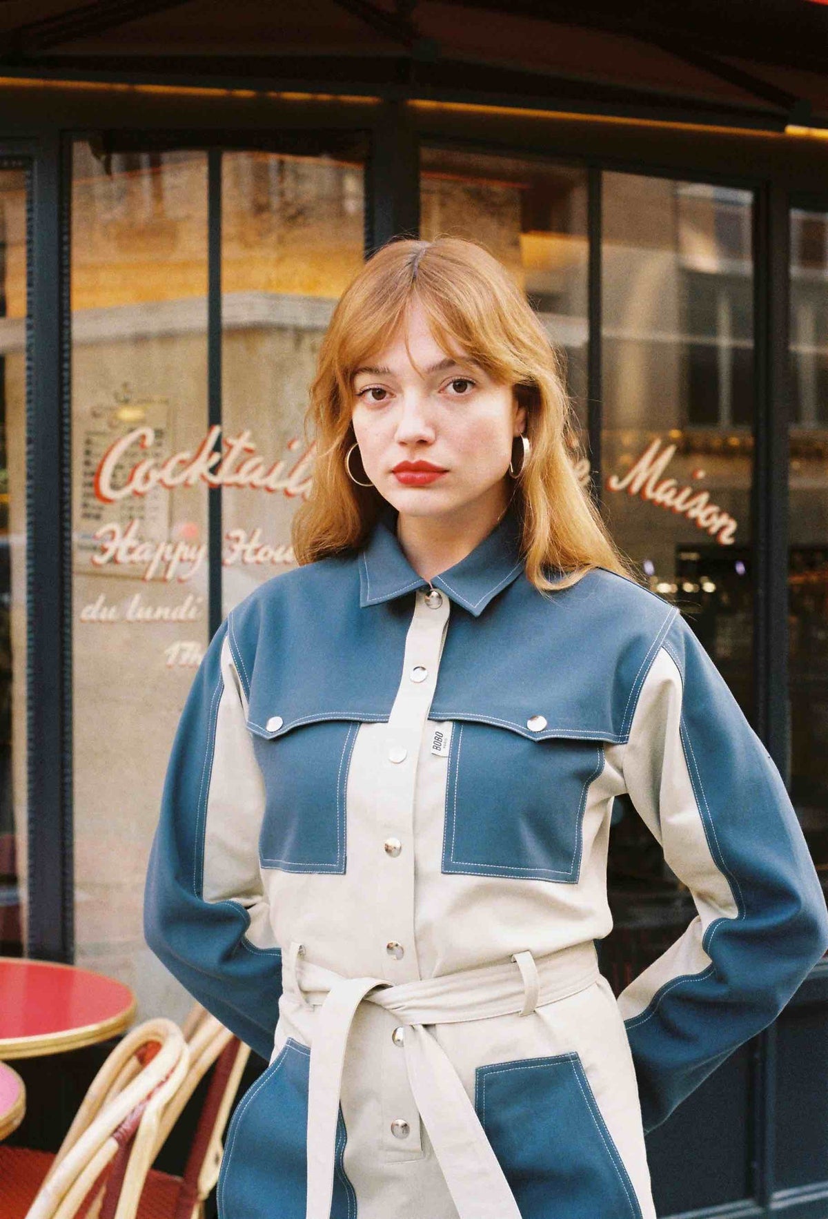 Combinaison Claudia, porté de face dans la rue, elle est réalisée dans un tissu 100% coton et est dotée de finitions inspiration trench (bavolets)